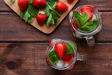Summer refreshment drinks. Fresh strawberry lemonade with ice and mint on a wooden table. Close-up, selective focus, top view