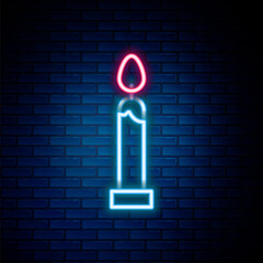 Glowing neon line Burning candle icon isolated on brick wall background. Cylindrical candle stick with burning flame. Colorful outline concept. Vector