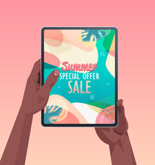african american human hands using tablet pc with summer sale banner flyer or greeting card on screen