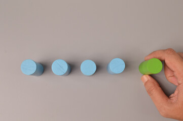 Man hand choosing a green wooden block. Business choice and leadership