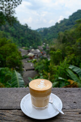Latte art coffee on wooden table at Chom Nok Chom Mai at Mae Kam Pong, Chiang mai, Thailand
