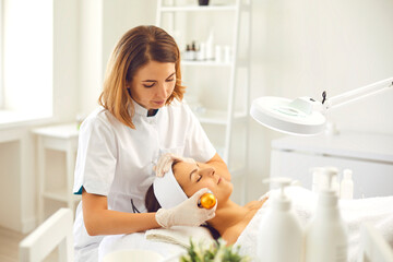 Woman dermatologist making apparatus phonophoresis face procedure with hyaluronic acid gel for...