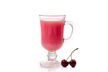 Milk cocktail with cherry in a clear glass and berries on a light background.