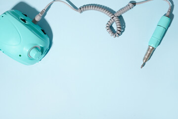 Machine for hardware manicure on blue background, nail Polish. Nail care. copy space