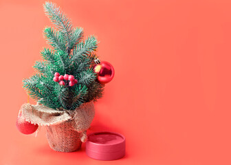 little Christmas tree with toys on a red background with a place for text