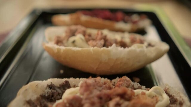 Three traditional Mexican molletes on a black tray