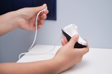 Woman's hand plugging in her air pulse stimulator vibrator