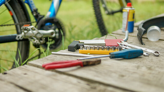 father and son maintain bike on a sunny summer day