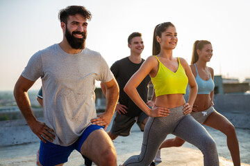 Group of happy friends working out together outdoors. Fitness, training, sport and people concept