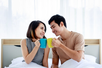 Happy couple drinking coffee in bed