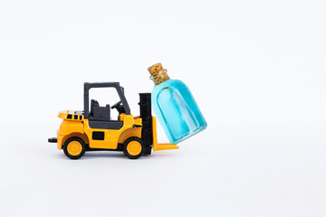 Yellow forklift truck with bottle of ethyl alcohol isolate on white background, health care and medical industry, export and import business