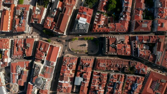 Aerial birds eye overhead top down view of streets and houses with red rooftops in town. Luis de Camoes Square from drone. Lisbon, capital of Portugal.