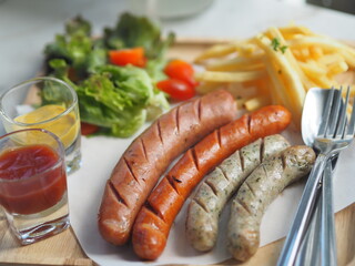 Various flavors of pork sausages on wooden tray with Mayonnaise and Tomato sauce in clear glass, food