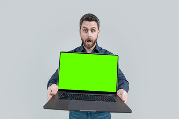 shocked mature man businessman presenting computer showing its green screen for copy space, webinar