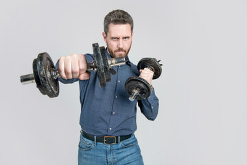 Fototapeta na wymiar successful strong mature businessman with beard training punching with barbells, copy space, power.