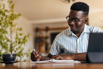 Adult black man, writing down his thoughts.