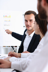 Group of people deliberate on white board problem