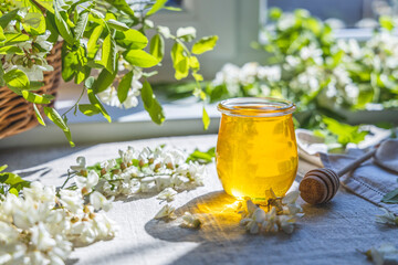 Sweet honey jar surrounded spring acacia blossoms