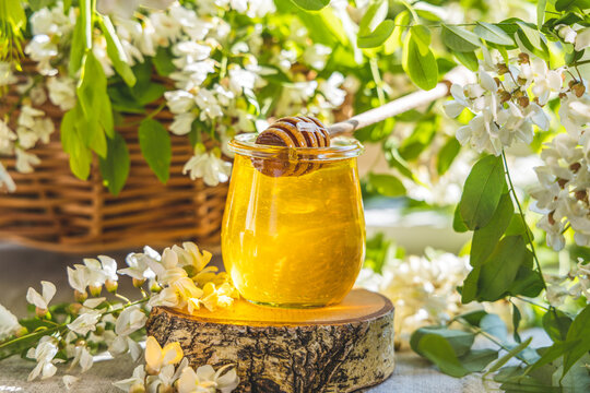 Sweet honey jar surrounded spring acacia blossoms