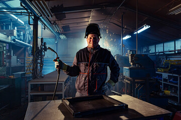 Portrait of a smiling welder posing in the factory