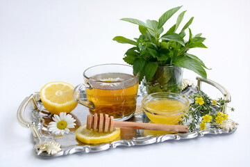 Tea with chamomile, lemon and honey on a white background