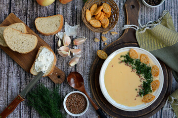 Creamy potato soup with cheese, croutons and herbs. Top view