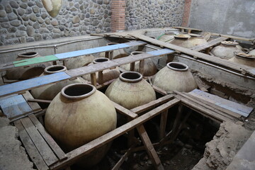 Old ceramics wine jars called kvevri at the wine factory in Georgia. Traditional ceramic pottery...
