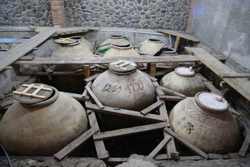 Old ceramics wine jars called kvevri at the wine factory in Georgia. Traditional ceramic pottery...
