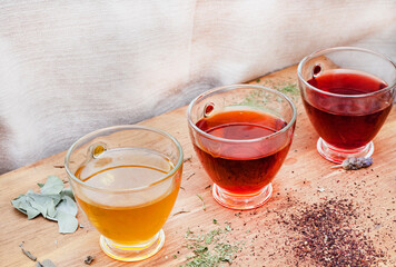 various herbal teas in glass cups on wooden surface