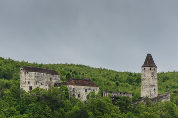 Fototapeta na wymiar old castle in green hills and rain clouds detail