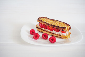 custard cake with cream and strawberries on a white plate