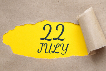 july 22. 22th day of the month, calendar date.Hole in paper with edges torn off. Yellow background is visible through ragged hole.Summer month, day of the year concept