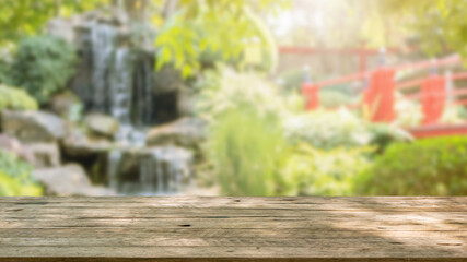 Naklejka na ściany i meble Empty wood table top with abstract blur park garden pond background
