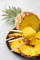 Ripe juicy pineapple cut into rings close-up, pineapple in the form of ice cream on a stick