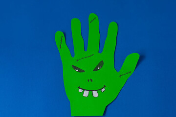 Step 3. Step-by-step instructions on how to make a funny hand-shaped monster out of colored paper. DIY concept. Children's art project. Halloween decoration