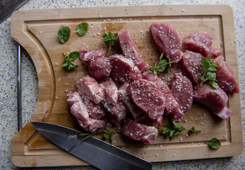raw meat pieses on a wooden plate