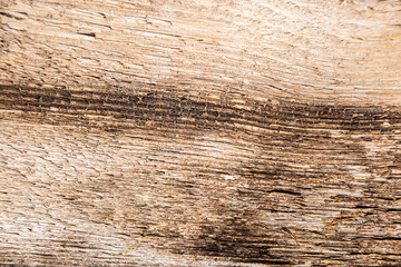 Dark brown aged wooden textured rough background with stains and cracks.