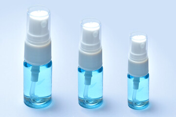 Alcohol, ethanol in 3 clear bottles sprayed to kill germs of the Covid 19 virus on a white background