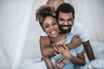 Man hugging his wife in morning in bedroom