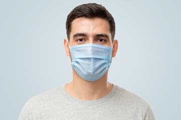 Young handsome man wearing t-shirt and medical mask