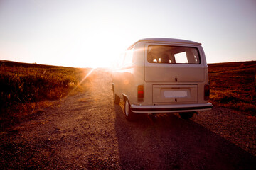 Bus Vintage su strada sterrata con sole frontale al tramonto