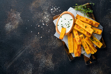 Homemade polenta chips fries with sea salt, parmesan, thyme, rosemary with yogurt sauce. Typical...