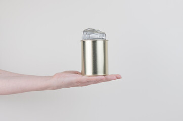 Female hand holding a tin can