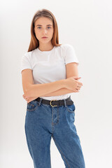 portrait of young attractive caucasian woman with long hair in t-shirt and blue jeans isolated on white studio background. skinny pretty female posing on cyclorama. model tests of beautiful lady
