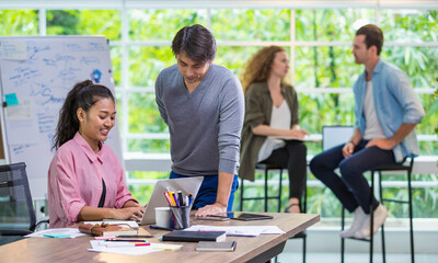 Multiracial diverse creative businesspeople planning marketing stretegy together, comfortable meeting and working in modern indoor office with happy atmosphere. Selective focus on Asian employee.