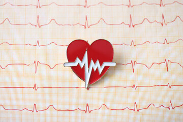 Electrocardiogram with emblem of the heart lie on table at cardiologist