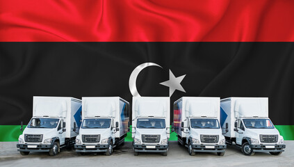 Libya flag in the background. Five new white trucks are parked in the parking lot. Truck,...