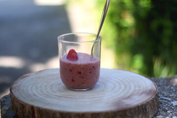 Banana and berry nice cream, served in a garden. Selective focus.
