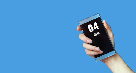 june 04. 04th day of the month, calendar date.Woman's hand holds mobile phone with blank screen on blue isolated background.Summer month, day of the year concept