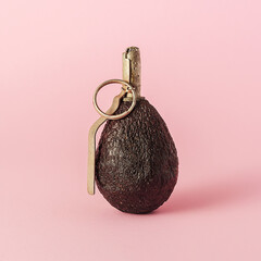 The creative concept of the diet. Avocado in the shape of a grenade on a pink background.